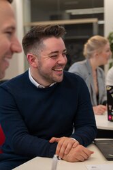 IT-Mitarbeitende von REWE digital arbeiten an bestickerten Laptops in einem hellen Büro mit Pflanzen